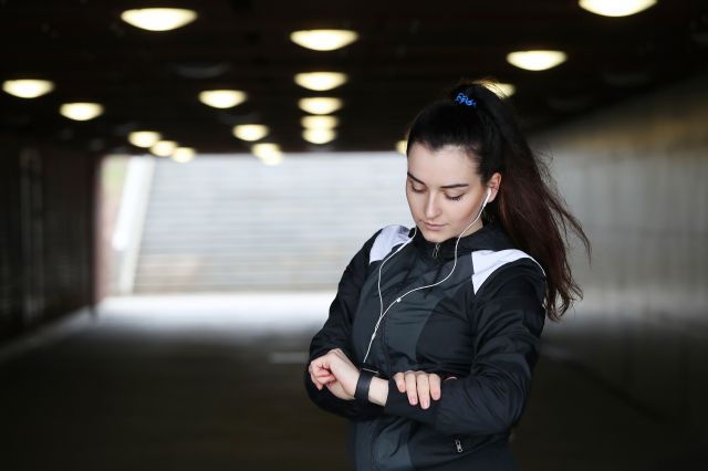 Athlete using a wearable health tracker to assess performance readiness, questioning its effectiveness.